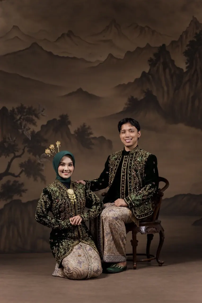 Ibnu dan Rheinata berpose bersama dalam busana adat Jawa
